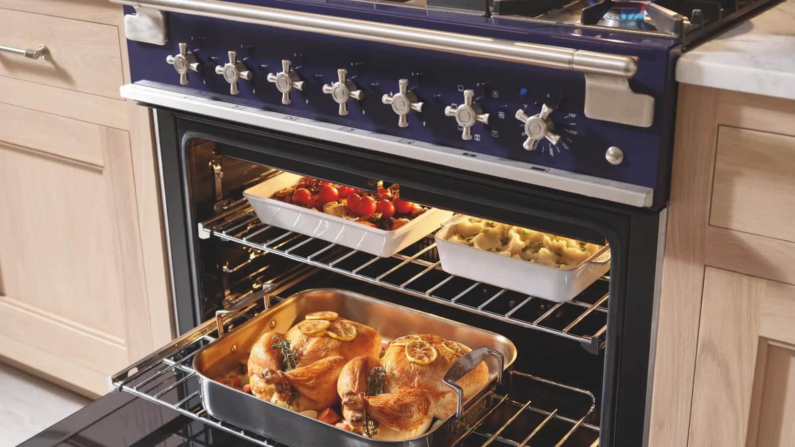 A cobalt blue AGA cast-iron range with the ovens open on a roast