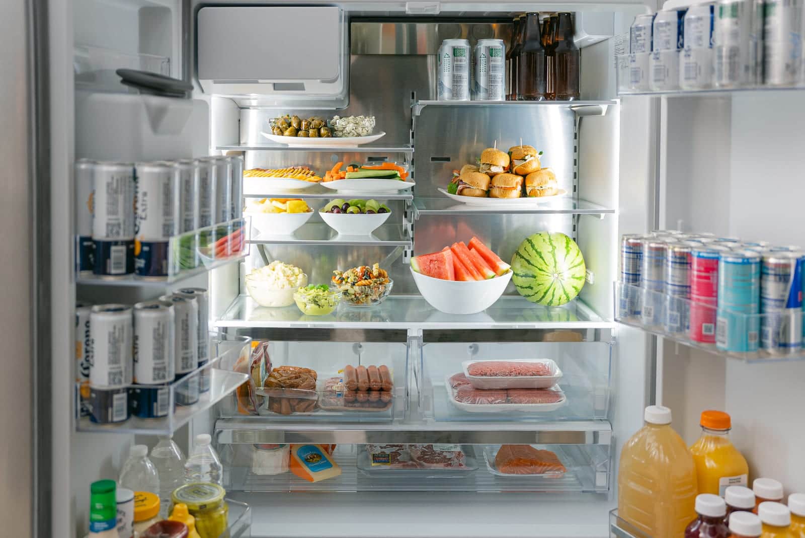 An open Bosch refrigerator holding platters across its shelves