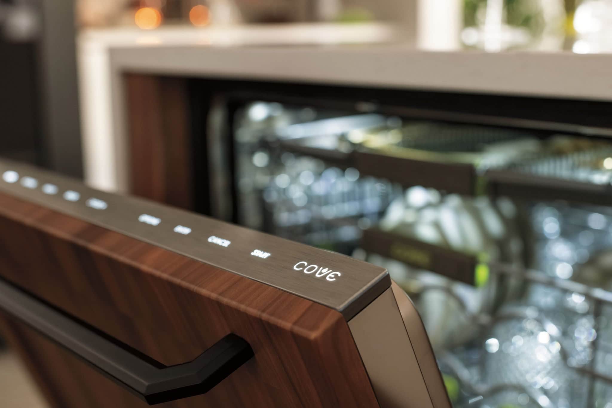 The lit control strip along the top edge of an open panel-ready Cove dishwasher