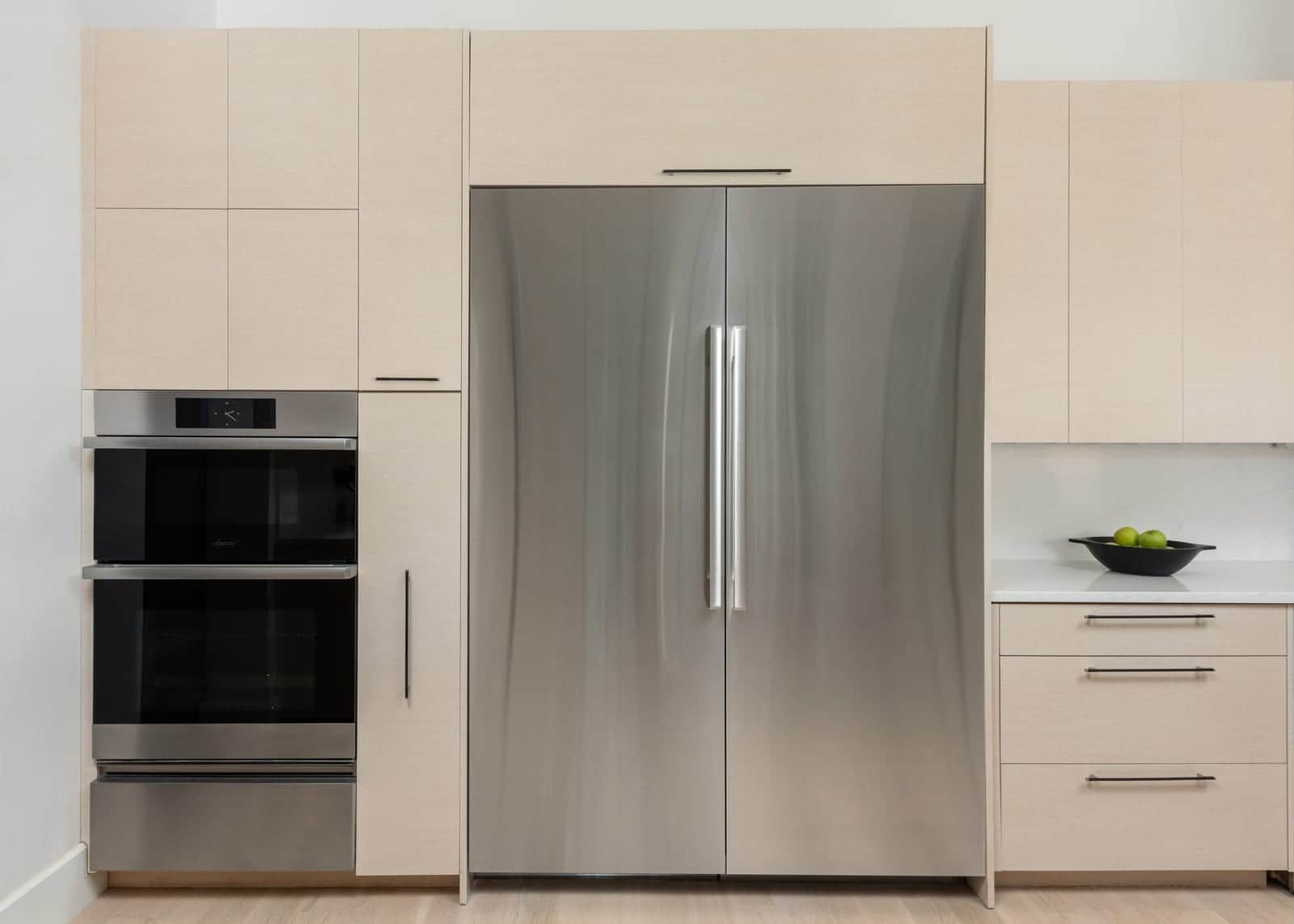 A Dacor column refrigerator beside a double wall oven in a pantry