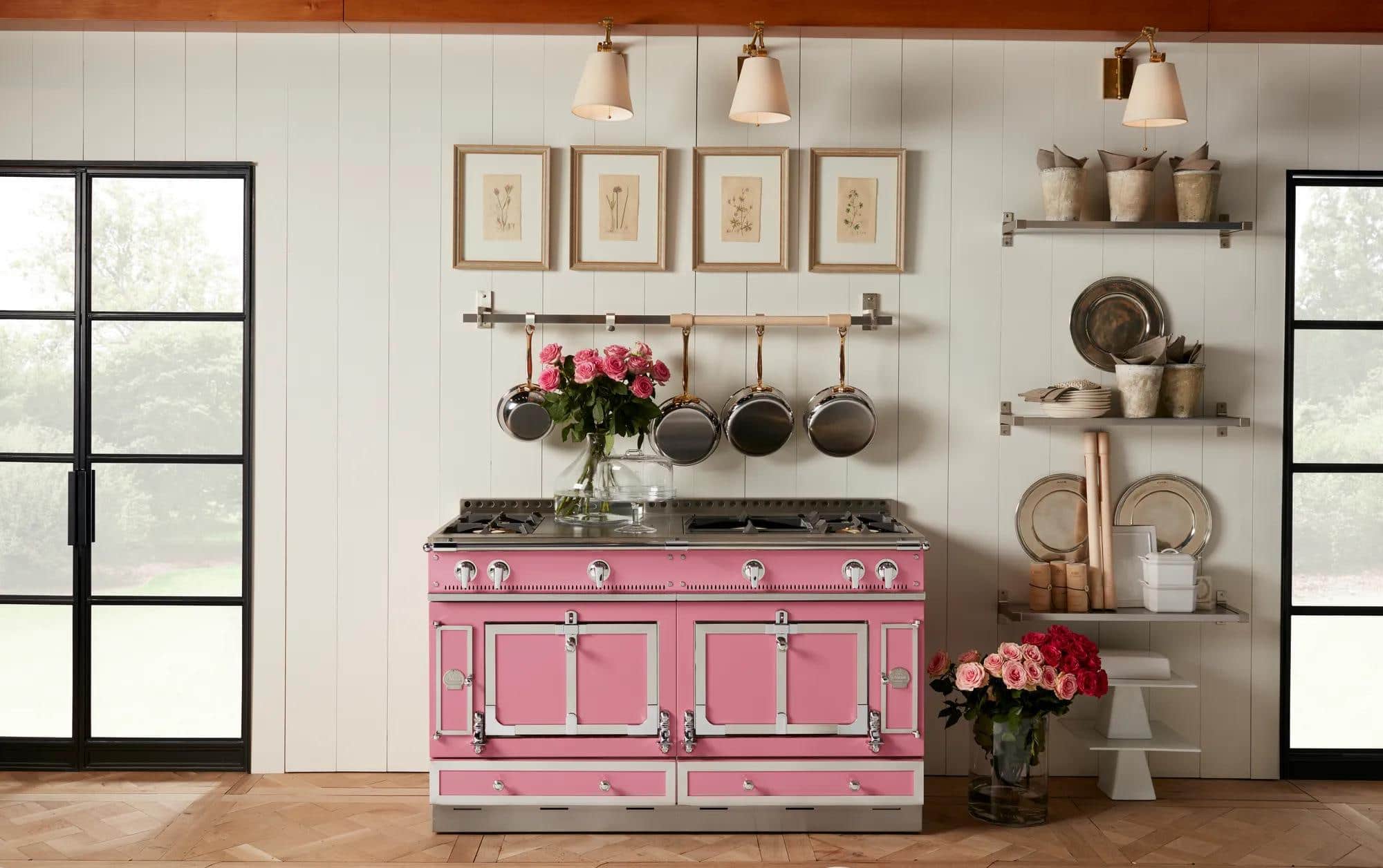 A pink La Cornue range with silver trim against a white panelled wall