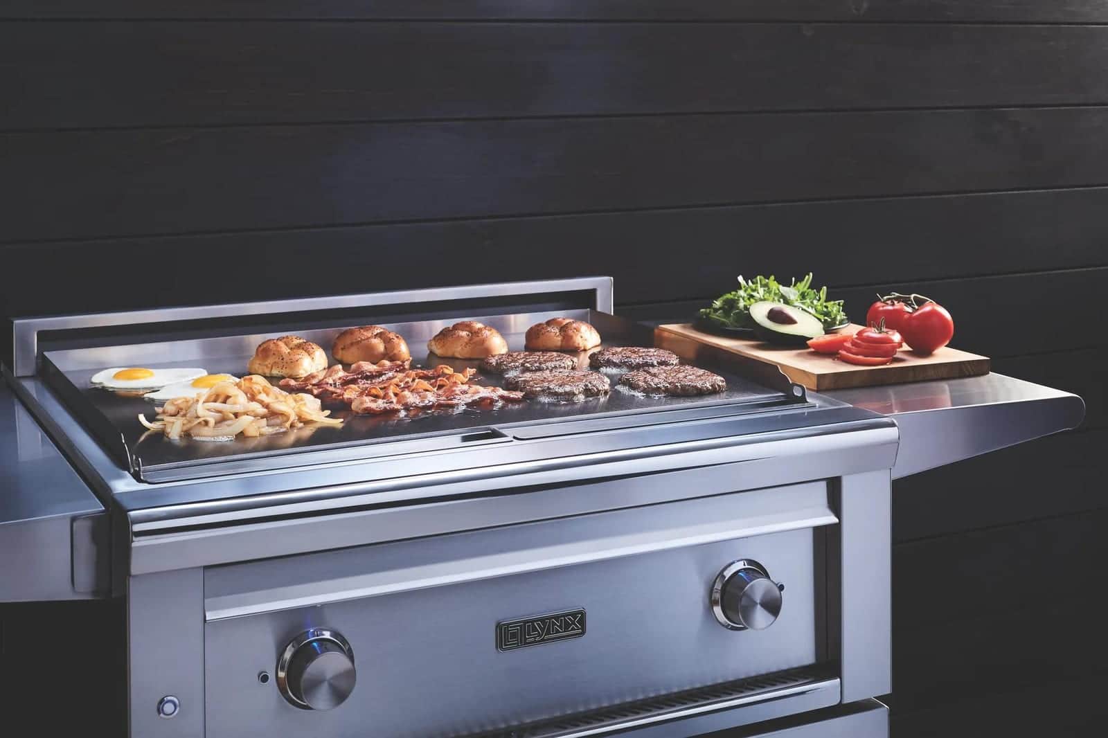 Burgers and eggs cooking on a Lynx flat-top griddle module