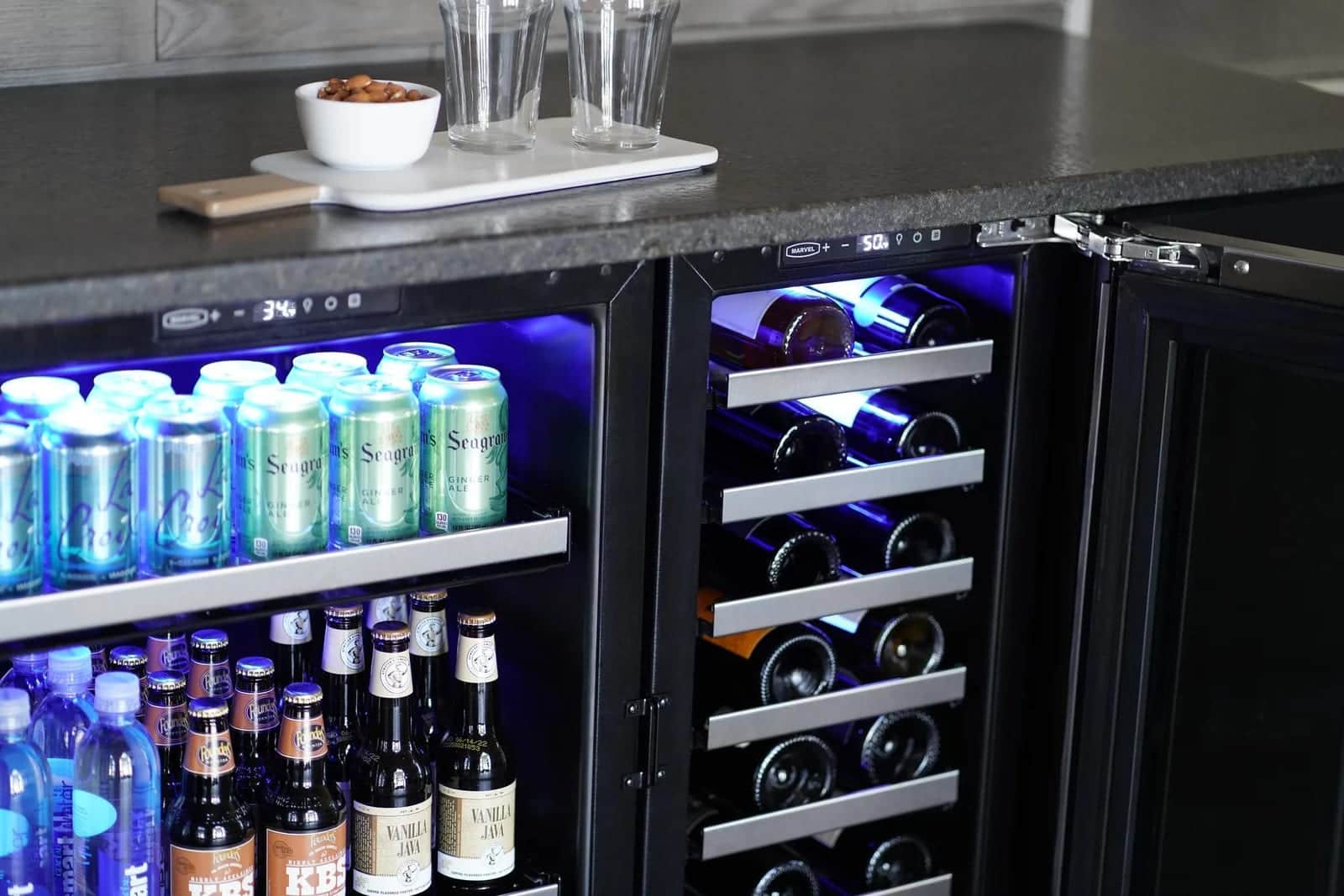 A Marvel dual-zone wine cellar lit blue beside a beverage center