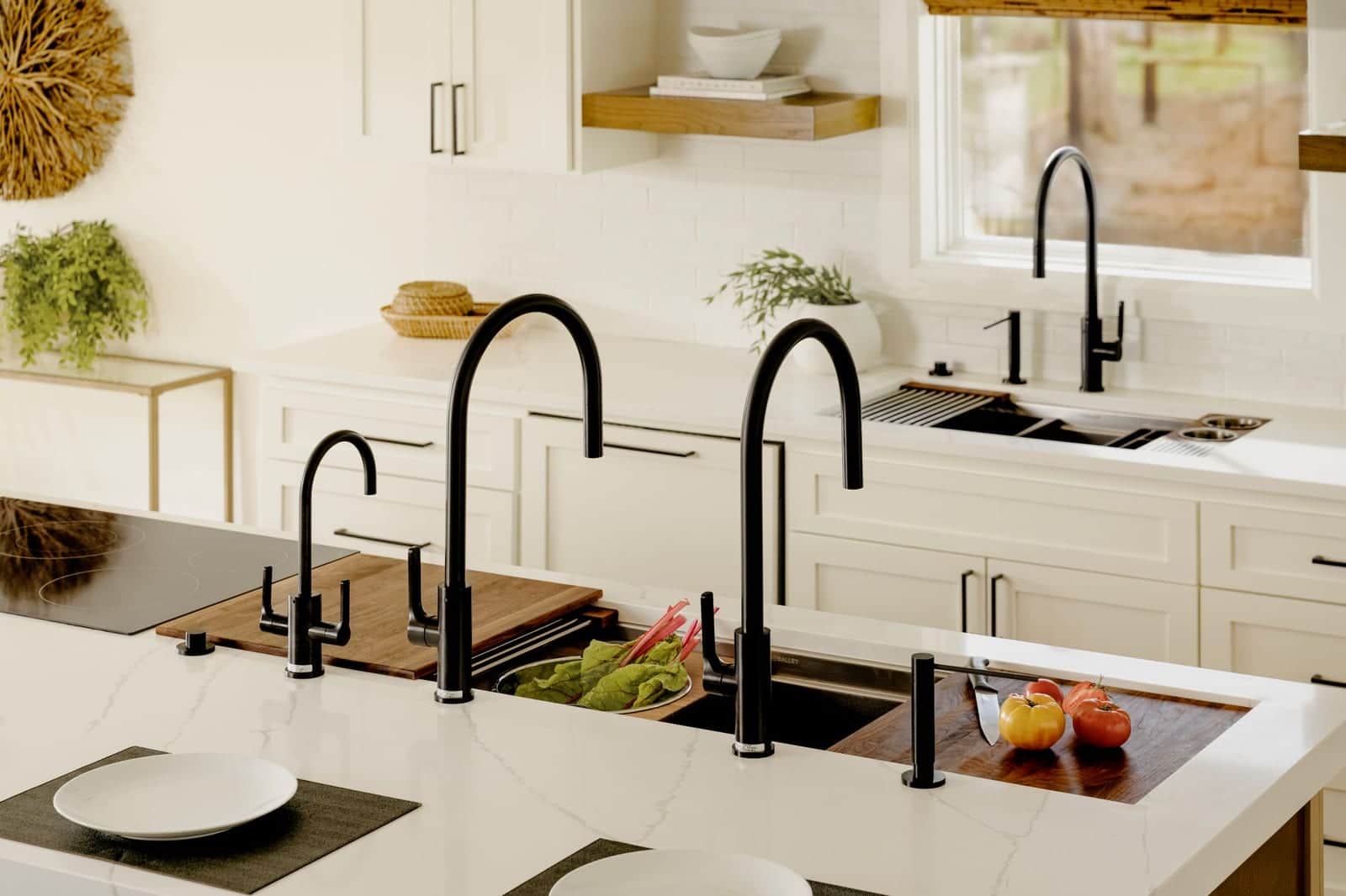 A Galley workstation sink with black taps and boards in a white kitchen