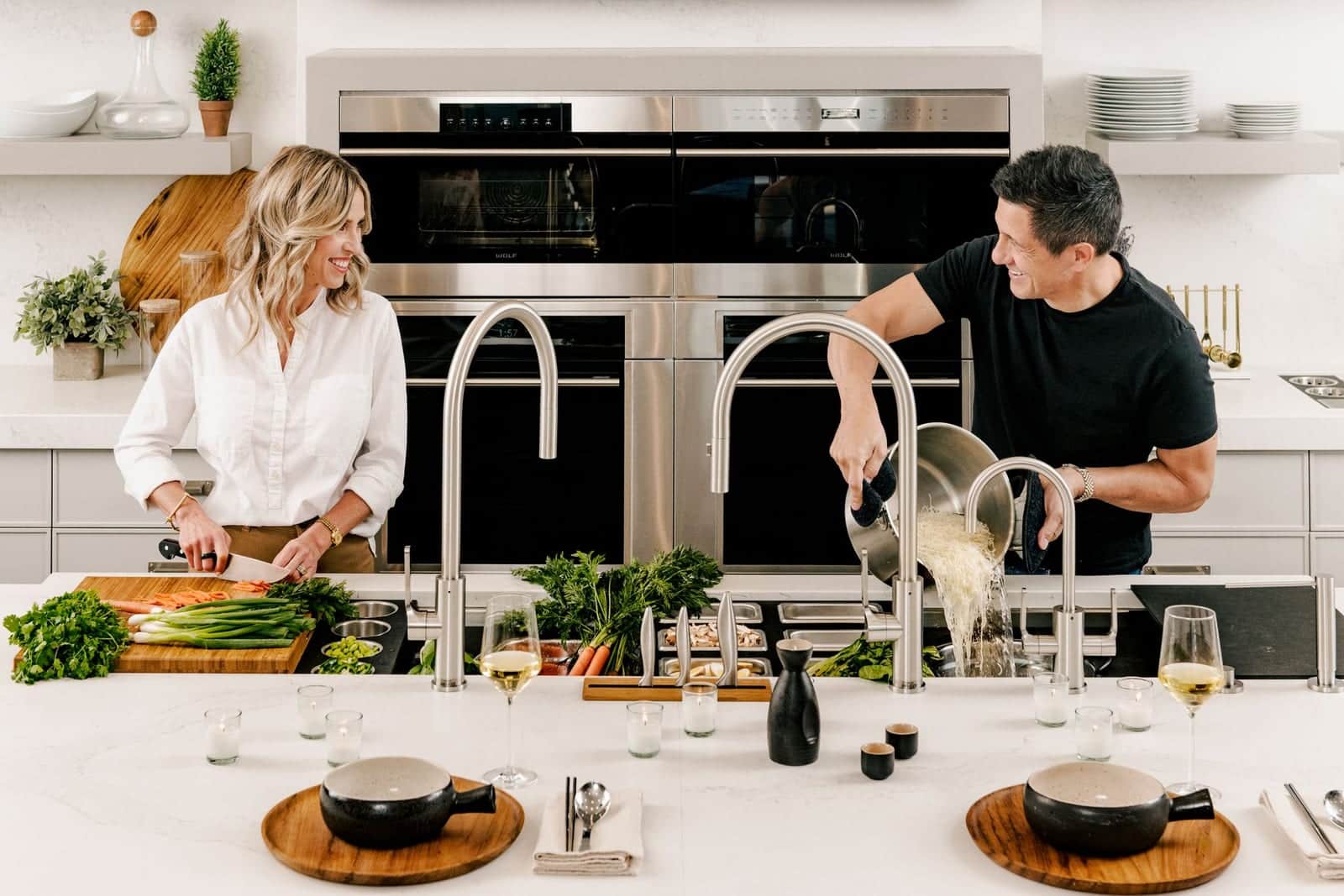 A couple prepping vegetables over a Galley workstation sink