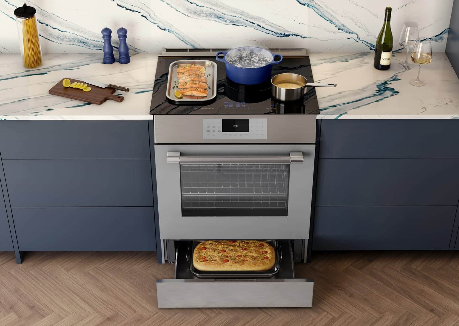 An open Thermador warming drawer holding fresh focaccia in a navy kitchen