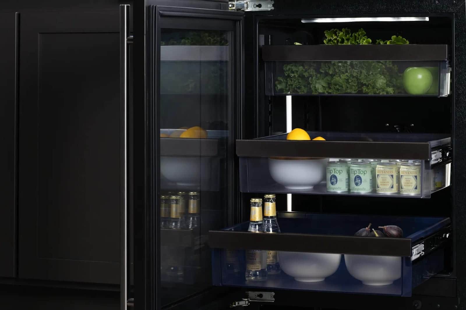Open black U-Line refrigerator drawers stocked with produce