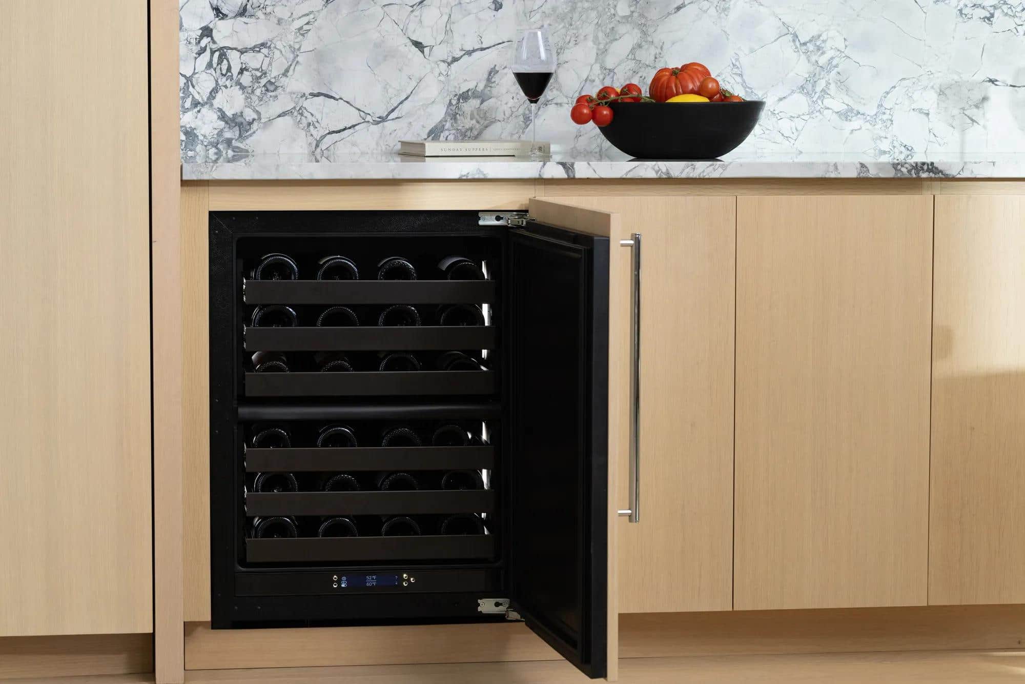 An open U-Line wine refrigerator set into pale oak cabinetry