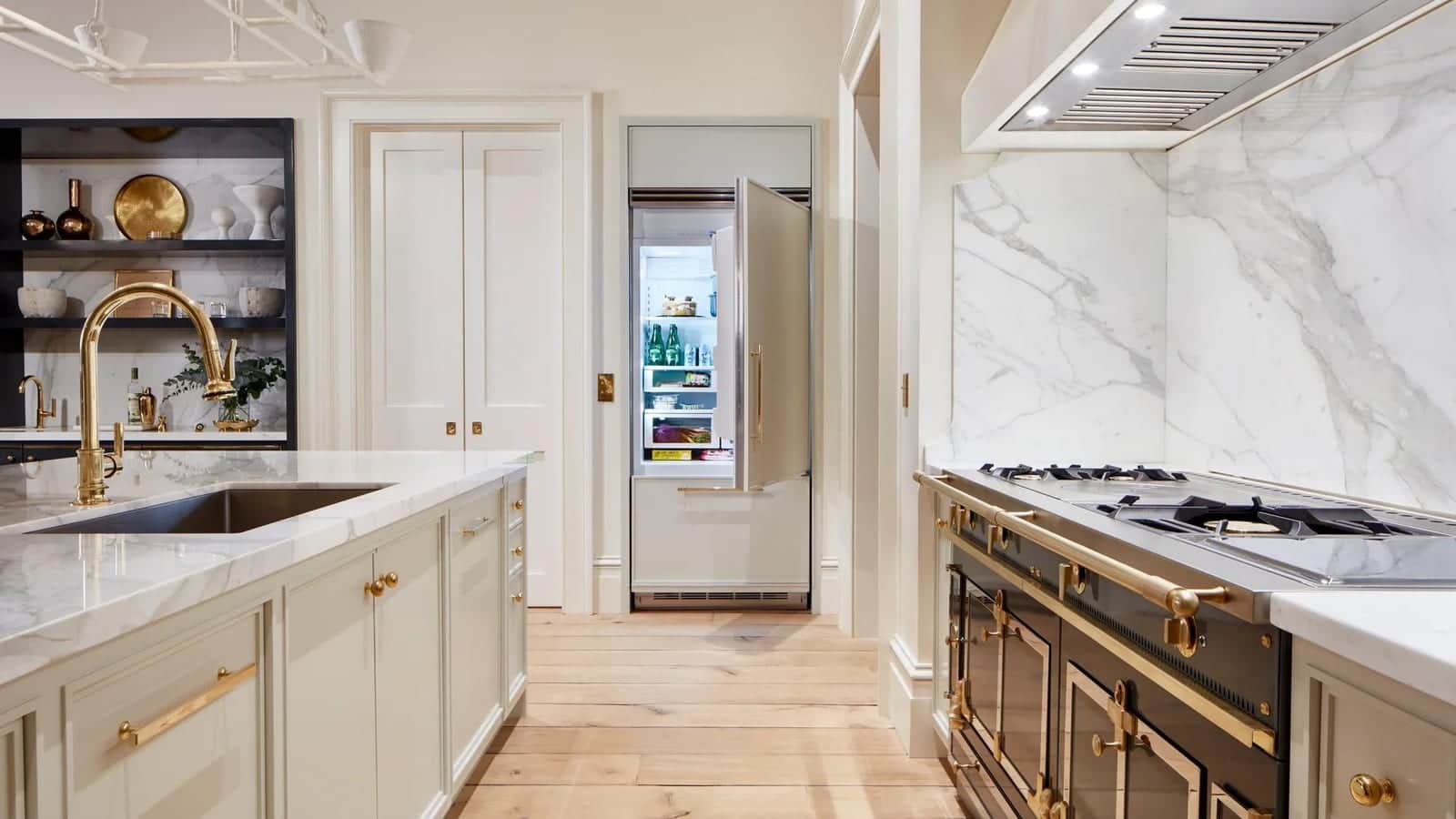 A black Viking range with brass trim against a figured marble backsplash