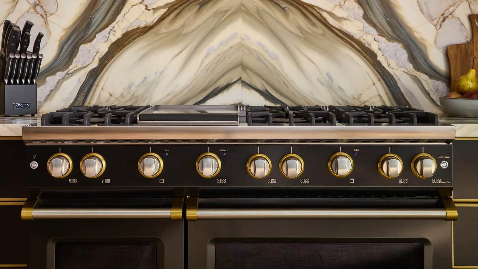 Close view of the brass control knobs on a black Viking range