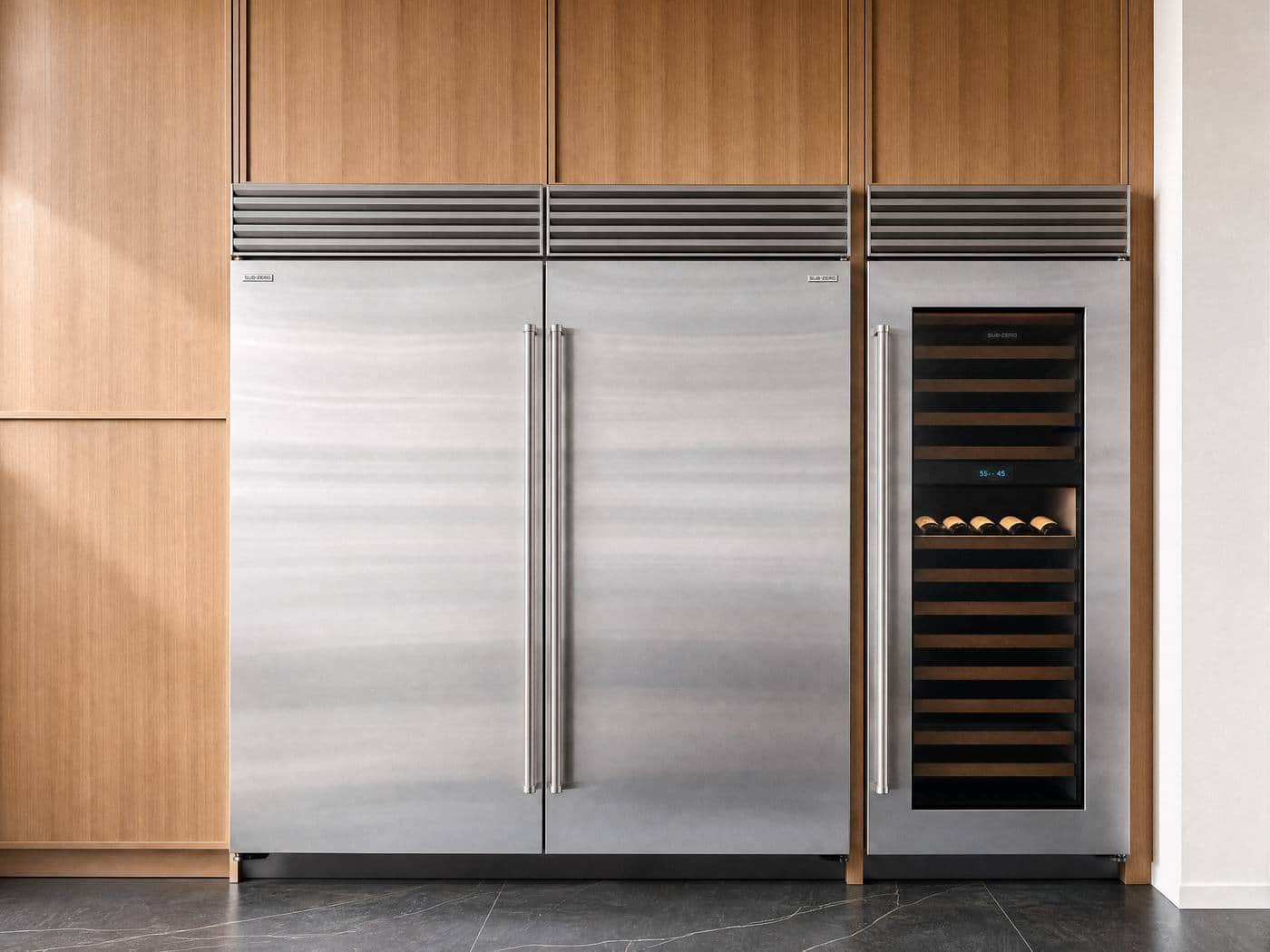 Sub-Zero refrigerator and freezer columns beside a glass door wine column, set into white oak cabinetry