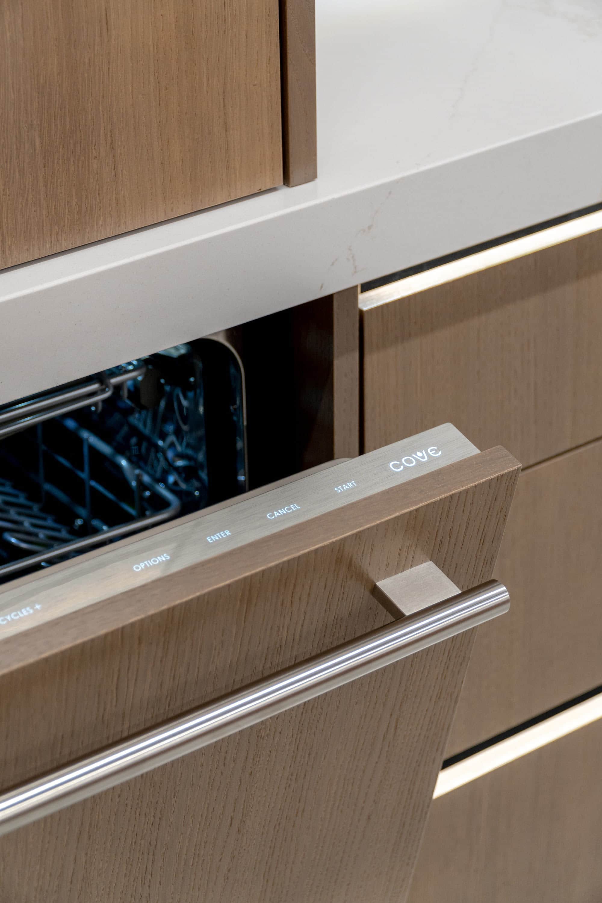 Lit control bar along the top edge of an open Cove panel-ready dishwasher in the Post Falls showroom