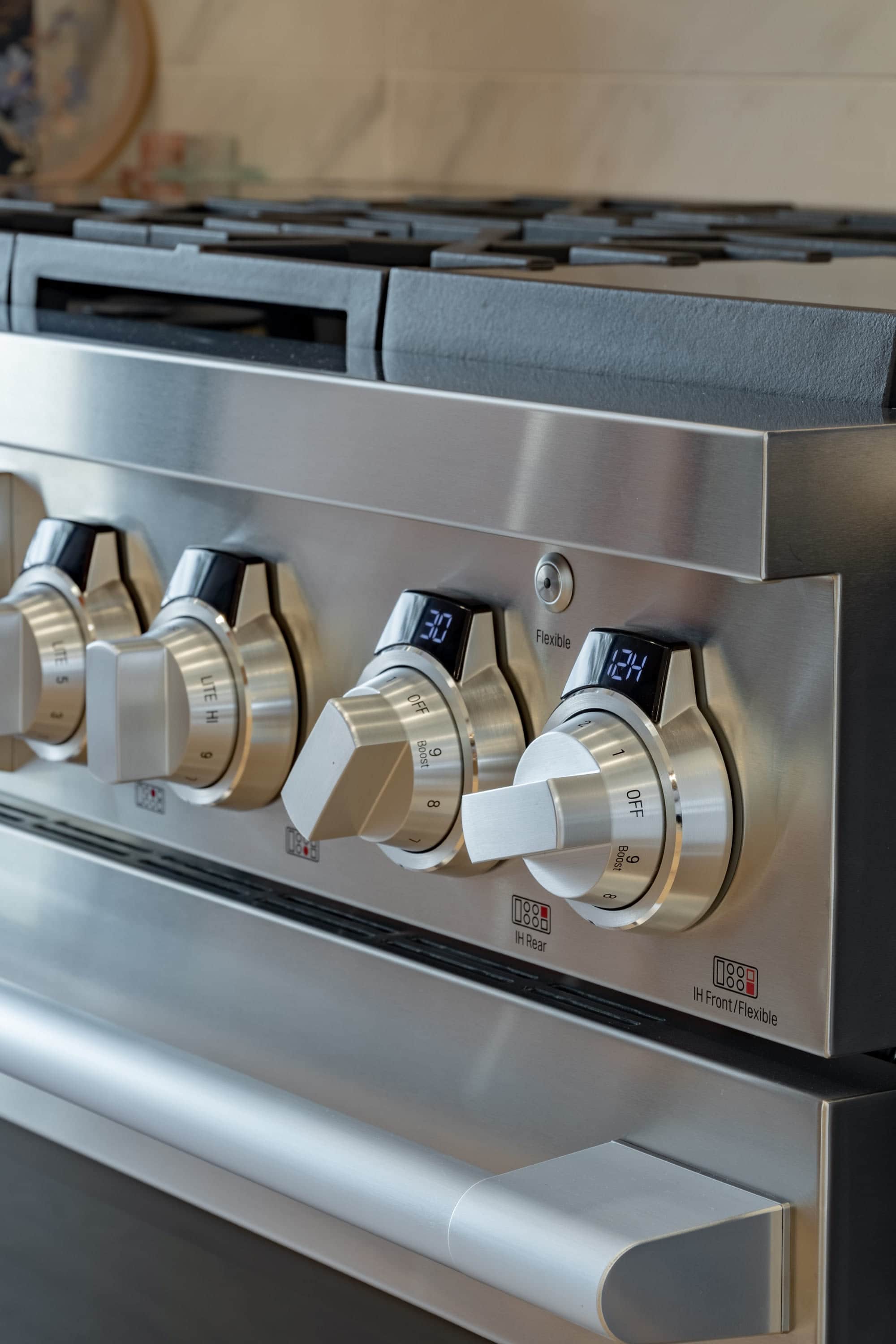 Machined steel control knobs along the fascia of an SKS professional range