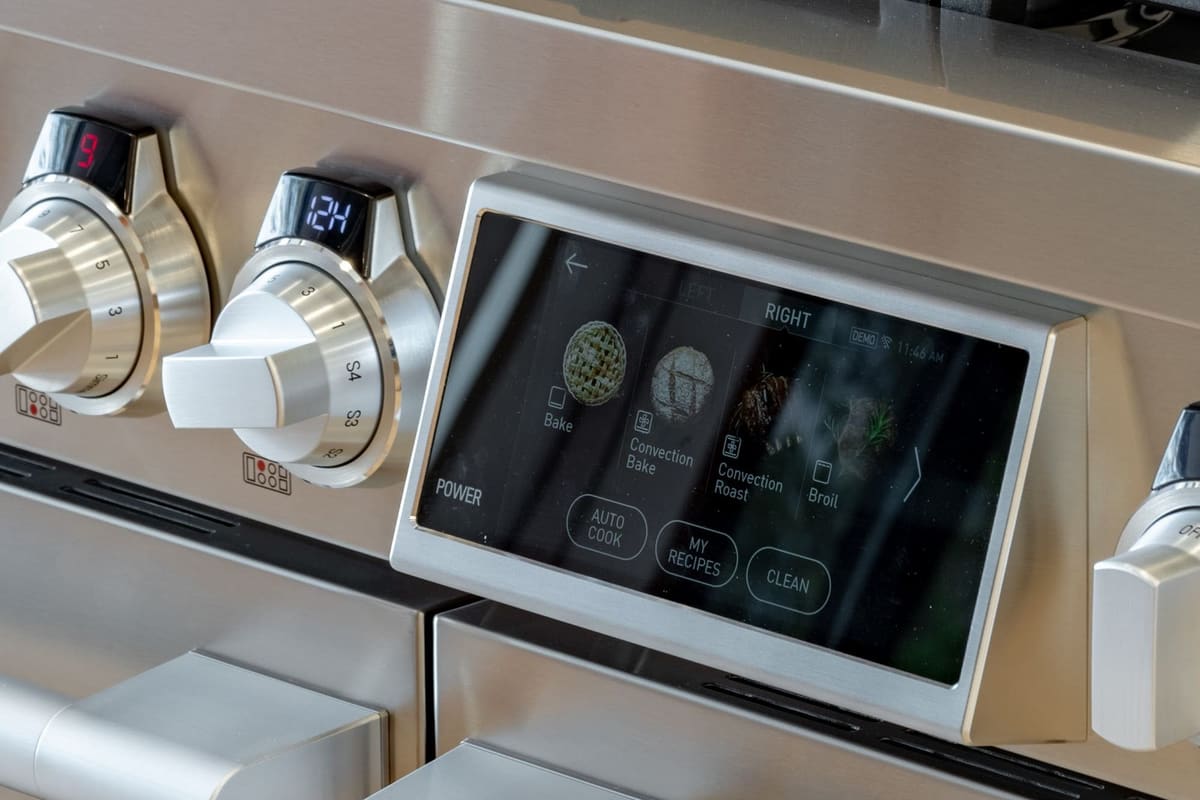 SKS professional range with brushed steel control knobs and a lit cooking mode display set into the stainless fascia